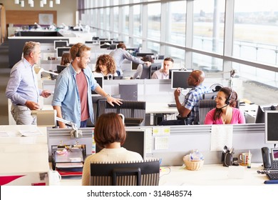 Casually dressed colleagues talking in an open plan office - Shutterstock ID 314848574