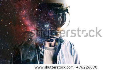 Casually dressed sad looking man in a large helmet with bright stars and galaxies projected on the shield and behind his back with white background in front of him. Double exposure