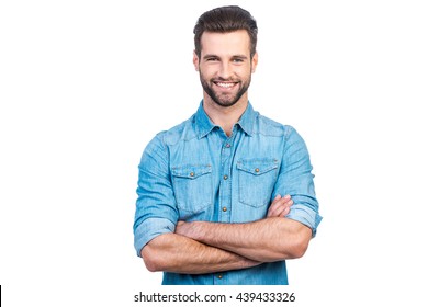 Casually handsome. Confident young handsome man in jeans shirt keeping arms crossed and smiling while standing against white background  - Shutterstock ID 439433326