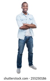 Casually Handsome. Full Length Of Handsome Young Black Man Keeping Arms Crossed And Smiling At Camera While Standing Against White Background 