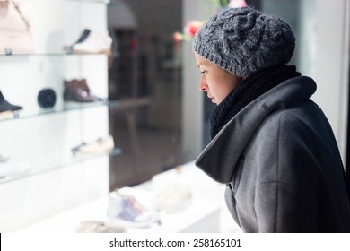 Casualy Winter Dressed Lady Window Shopping In Front Of Sinfully Expensive Boutique Store Dispaly Window. Customer Woman In Shopping Street, Looking At Window, Outdoor.