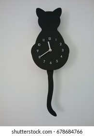 Cat Clock On A White Wall Background