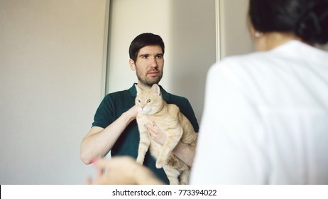 Cat Owner Man Talking With Vet Woman In Veterinarian Office