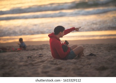 Cat And Its Owner On The Beach At Sunset Time