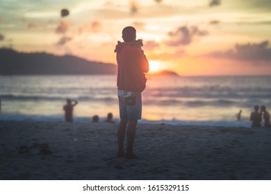 Cat And Its Owner On The Beach At Sunset Time