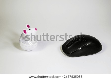 Cat toy mouse facing a computer mouse on white background, humorous tech and animal wordplay concept.