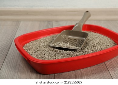 Cat tray with clumping litter and scoop on floor indoors, closeup - Shutterstock ID 2192555029