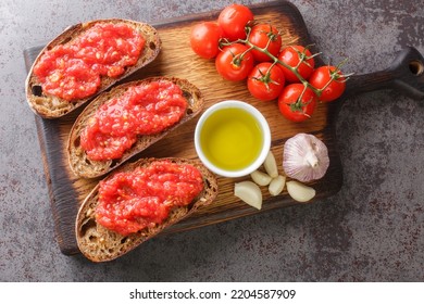 Catalan Pan Con Tomate Spanish Toasted Bread Rubbed With Fresh Garlic And Ripe Tomato, Then Drizzled With Olive Oil Closeup On The Wooden Board On The Table. Horizontal Top View From Above
