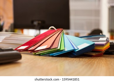 Catalog Of Colored Paper, Cardboard Lying On A Desk In A Modern Office. Focus On Colors That Are Trending In 2020 - Blue, Emerald, Green, Red, Shades Of Green, Yellow, Blue And Beige