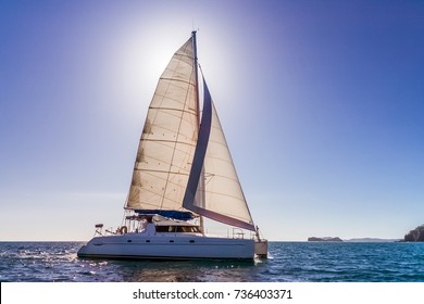 Catamaran Backlit With Sun Behind The Sail