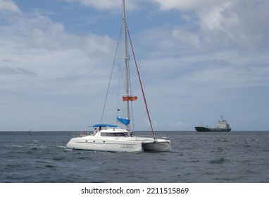 A Catamaran And A Cargo Ship Off The Coast Of Barbados In The Caribbean, April 2009