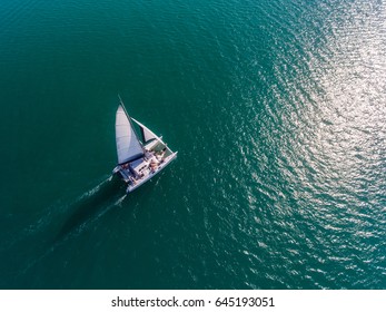 A Catamaran Moves Through The Teal Waters Of The Caribbean.