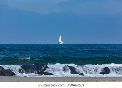 A Catamaran Sailboat Sails Past The Jetty In Deal, New Jersey. Tropical Storm Jose Made For Some Rough Water.