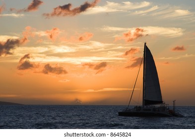 A Catamaran Sails At Sunset.