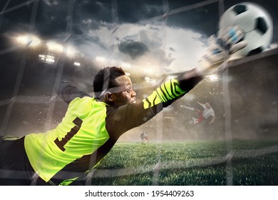 Catch. African male soccer or football player, goalkeeper in action at stadium. Young man catching ball, training, protecting goals in motion. Concept of sport, hobby, healthy lifestyle. Flashlights.