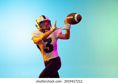 Catch ball. Portrait of male american football player playing, training isolated on blue background in neon light. Concept of sport, movement, achievements. Copy space for ad - Powered by Shutterstock