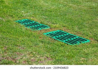 catch basin grate drainage on the lawn with green grass septic tank cover, two rectangular green eco hatches sump cesspool drainage system environment design, nobody.