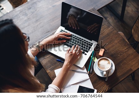 Catch up on some work. Close-up of woman using laptop while sitting at her working place