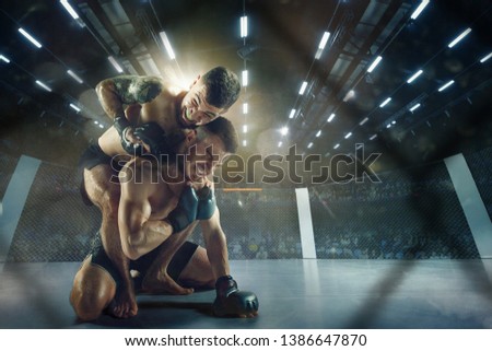 Catching breath. Two professional fighters posing on the sport boxing ring. Couple of fit muscular caucasian athletes or boxers fighting. Sport, competition and human emotions concept.