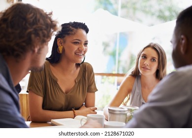 Catching up with old friends. Shot of a group of friends talking in a cafe. - Shutterstock ID 2128671020
