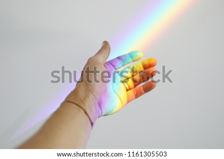 Foto Bild Frauenhand mit einem darin projizierten Regenbogen