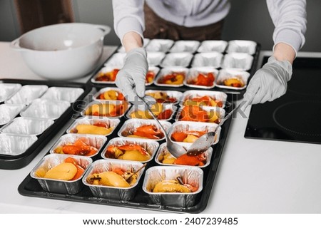 Caterer in a professional kitchen preparing individual servings of roasted vegetables, showcasing meticulous food service.