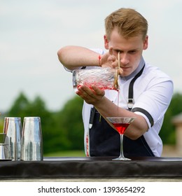 catering bar service. Bartender job on the departure. Handsome bartender preparing cocktail outdoors