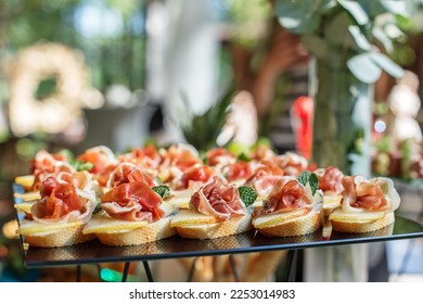 catering buffet table with snacks and appetizers. Set of canapés with jamon, bruschetta, pear and cheese and mint - Shutterstock ID 2253014983