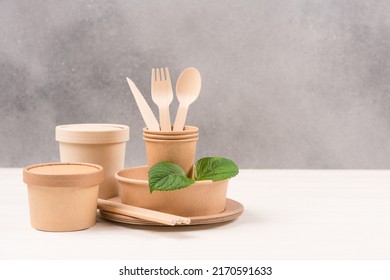 Catering, Paper Utensils - Paper Plates, Food Containers, Cups And Wooden Cutlery Set Against Gray Wall Background With Copy Space. Sustainable Food Packaging Concept