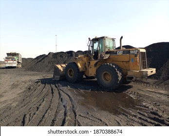 A Caterpillar Wheel Loader Working In A Coal Yard With Dirt And Sludge On The Ground   - Karachi Pakistan - Dec 2020