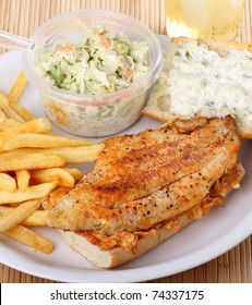 Catfish Fillet Sandwich With French Fries And Coleslaw On A Plate