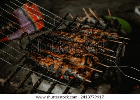catfish grilled over hot coals using a makeshift grill