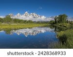 The cathedral group of mount teewinot, mount owen and grand teton reflected in the snake river, schwabacher