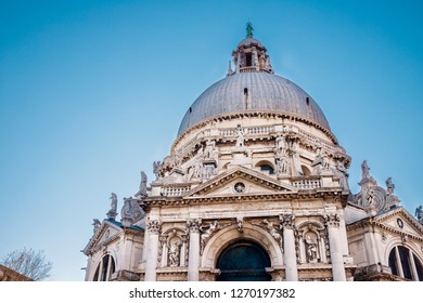 Cathedral Of Santa Maria Della Salute. Ffacade Is Decorated With Sculptures Of Archangel Michael Beating Satan, John Baptist And Virgin Mary