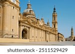 the Cathedral-Basilica of Our Lady of the Pillar, in Zaragoza, Spain, as seen from Plaza del Pilar square, with the Cathedral of the Savior or La Seo in the background on the right