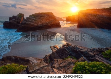 Cathedrals beach (Playa de las Catedrales) or Praia de Augas Santas at sunrise, amazing landscape with rocks on the Atlantic coast and colored sky, Ribadeo, Galicia, Spain. Outdoor travel background
