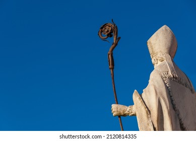Catholic Church. Bishop with mitre and crosier, an old white marble statue on Lucca old walls, erected in the 17th century (with copy space) - Shutterstock ID 2120814335