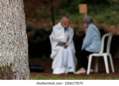 Catholic Church During Covid-19 Epidemic. A Penitent Confessing His Sins. Holy Confession. Sacrament Of Reconciliation.  Sanctuary Of La Benite Fontaine. France. 