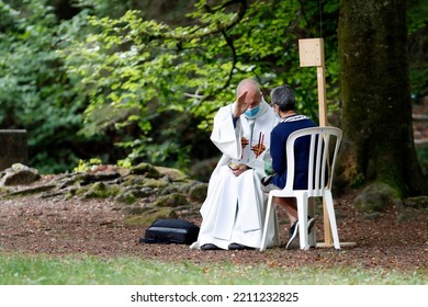 Catholic Church During Covid-19 Epidemic. A Penitent Confessing His Sins. Holy Confession. Sacrament Of Reconciliation.  Sanctuary Of La Benite Fontaine. France.  09-27-2020