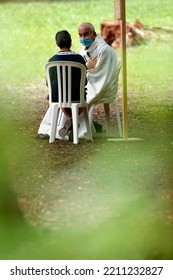 Catholic Church During Covid-19 Epidemic. A Penitent Confessing His Sins. Holy Confession. Sacrament Of Reconciliation.  Sanctuary Of La Benite Fontaine. France.  09-27-2020