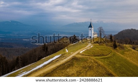 Catholic Church of St. Prim and Felician in the village of Jamnik, Slovenia. The time of the photo is in the morning in March. Remains of snow. Stock foto © 