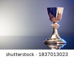 Catholic concept. Golden chalice on grey background.