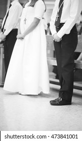 Catholic First Communion Religious Ceremony Girl In White Dress And Boys In Church.