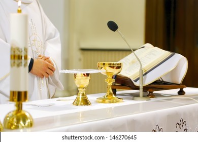 Catholic Mass - holly sacrifice of blood and body of Jesus Christ in landscape orientation photo, focused to hands of priest
