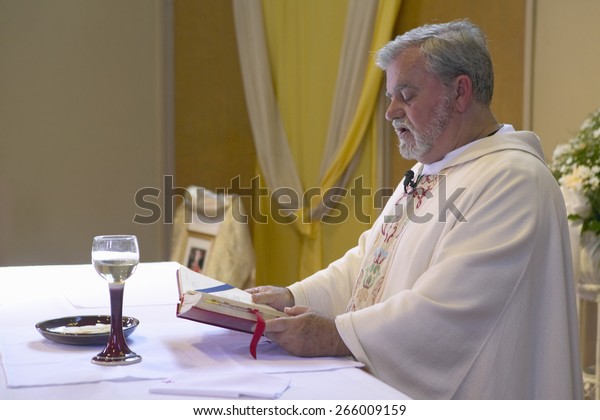 catholic priest administers wedding vows 600w 266009159