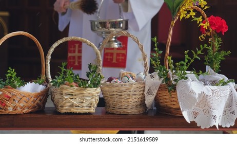 Catholic Priest Blessing Swieconka Easter Baskets With Food Using Holy Water On Great Saturday Polish Tradition Celebration