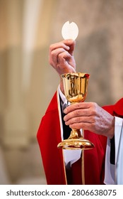 Catholic priest elevating the Eucharistic host above golden chalice during Holy Mass, symbolizing faith, consecration and Christian worship