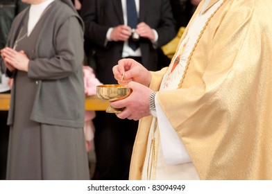 Catholic Priest Granting The Communion