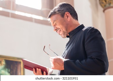 Catholic Priest Reading Bible In Church