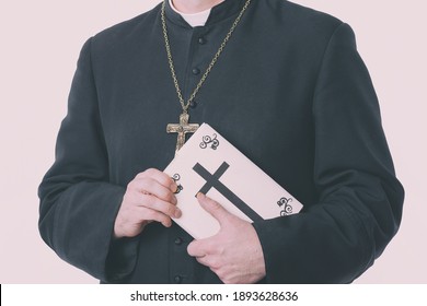 Catholic Priest's Hands Holding The Holy Bible